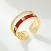 Oro blanco de 14k con circonio y aceite rojo oscuro.