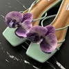 Un par de zapatos de orquídeas phalaenopsis moradas.