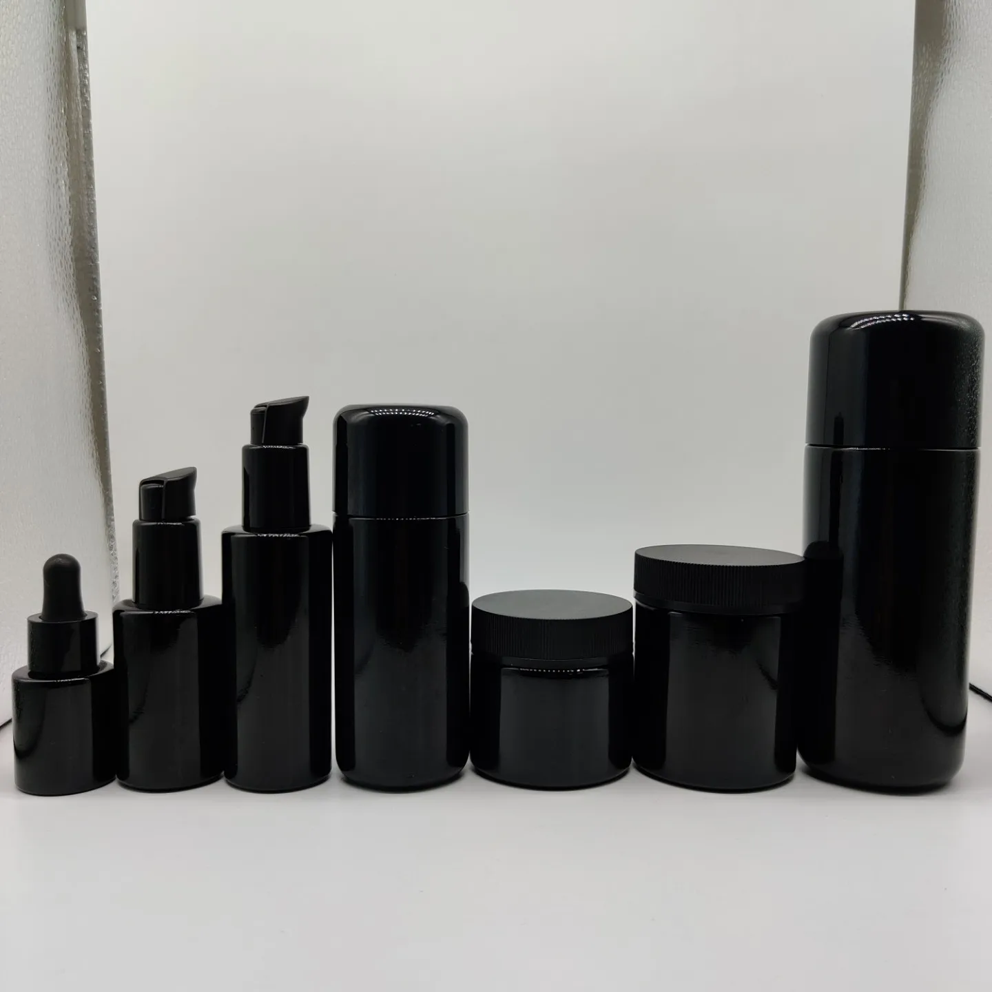 New Product 100ml 200ml Cylinder Frosted Black Lotion Glass Bottle with Matt Black Plastic Cap