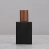 Botella de perfume negro con tapa de madera de nogal