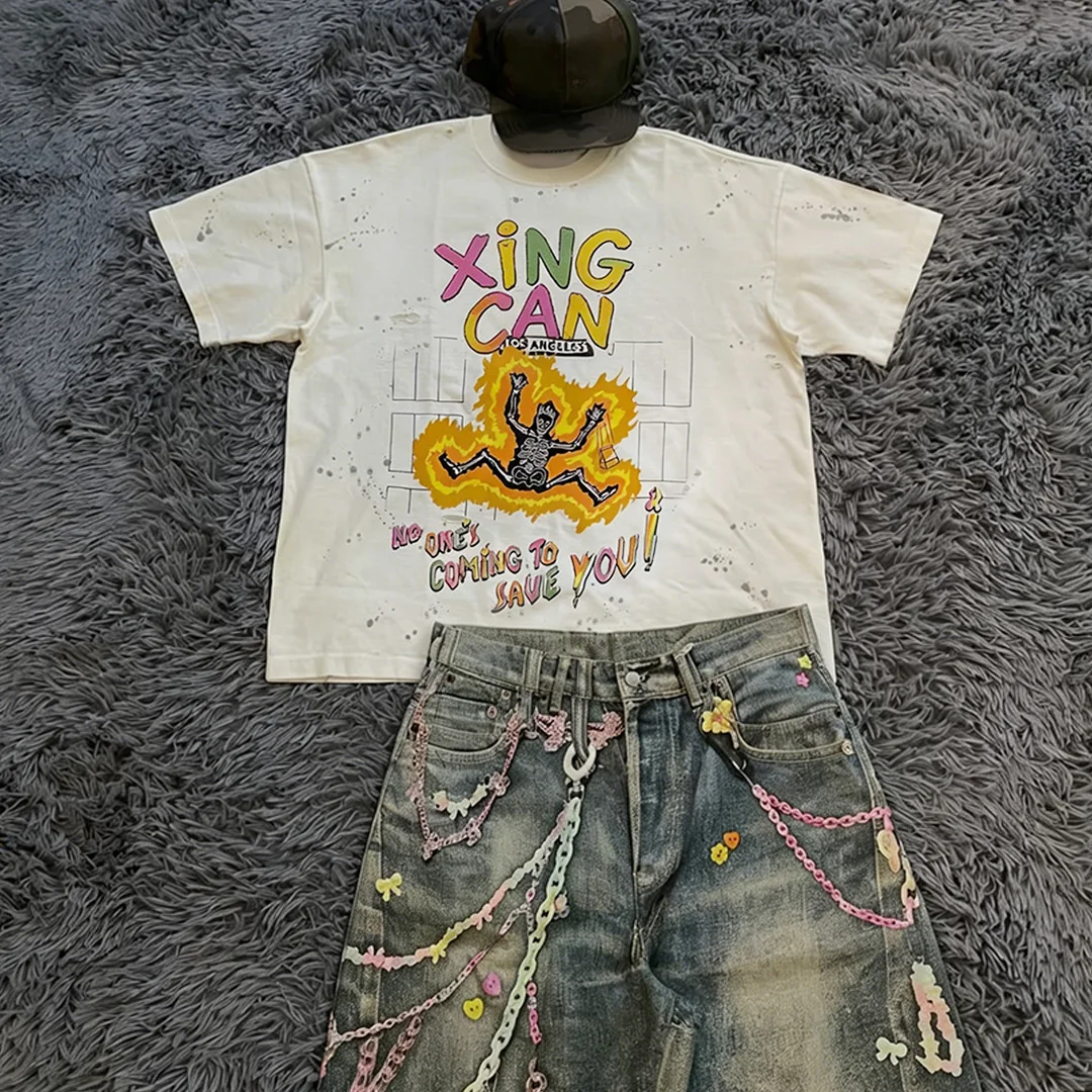 Zestaw męskich ubrań w stylu streetwear – ciężka koszulka z 100% bawełny z cyfrowym nadrukiem DTG, kroju boxy, w stylu vintage, wyblakła i luźna, oraz spodenki dżinsowe po praniu.