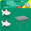 A black square table with two off-white low moon chairs.