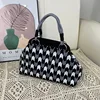 Bolso dumpling con flechas negras y grises.