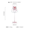Una copa de vino tinto con fondo cóncavo rosa de gatito