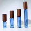 Dark blue bottle with silver nozzle and black walnut wood cap