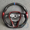 Fibra de carbono; cuero negro; sin botones; reposabrazos rojos