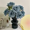 7 rosas en un jarrón azul en un jarrón de cristal negro