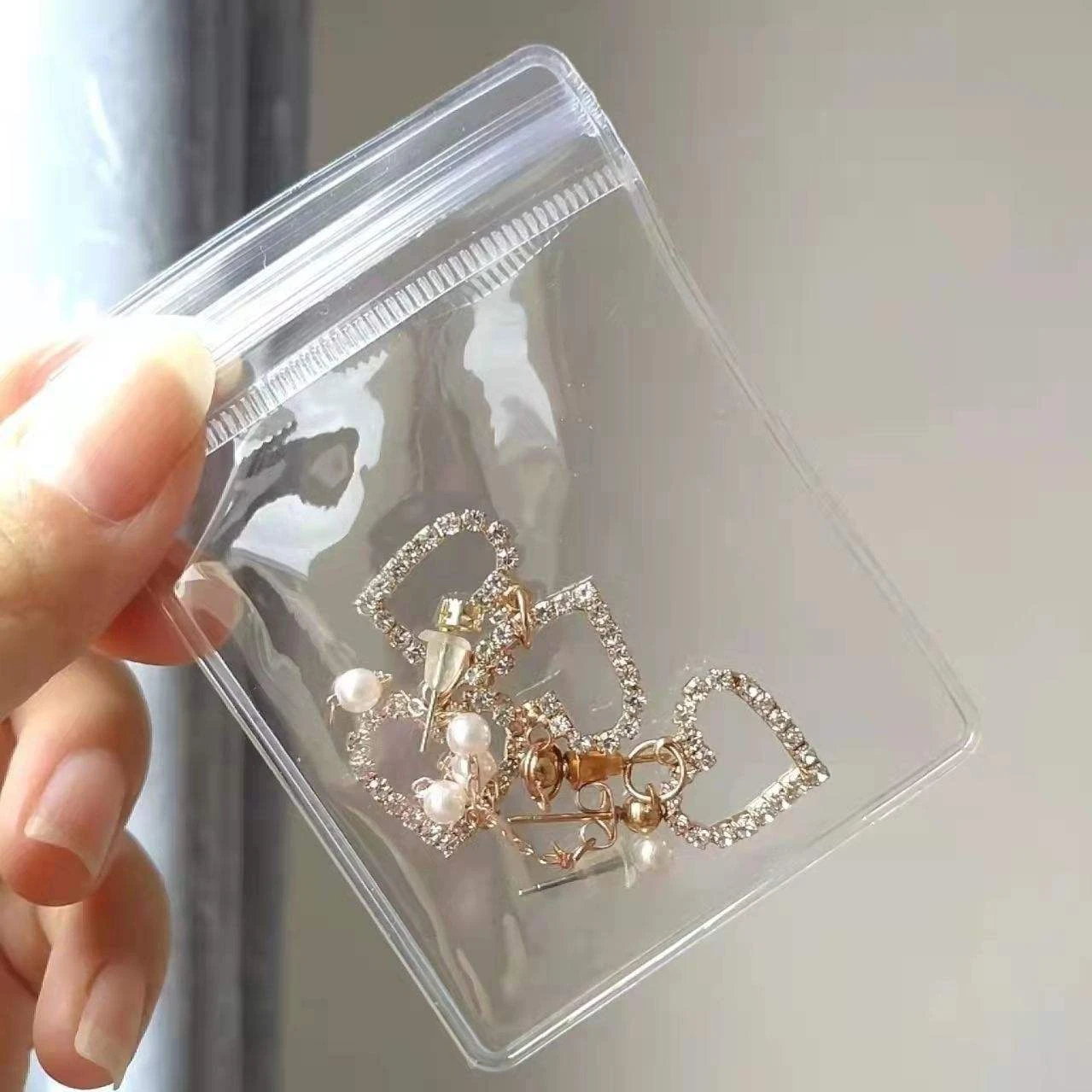 Transparent jewelry packaging with secure zip lock Clear PVC jewelry bags displaying bracelets with self seal closure