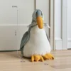 Fermaporta a forma di anatra colorata in stile cartone animato, di colore grigio.
