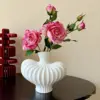 One Greek rose in a white vase with a painting of Greek roses.