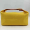 Amarillo El bolso tiene un logo "H" bordado.