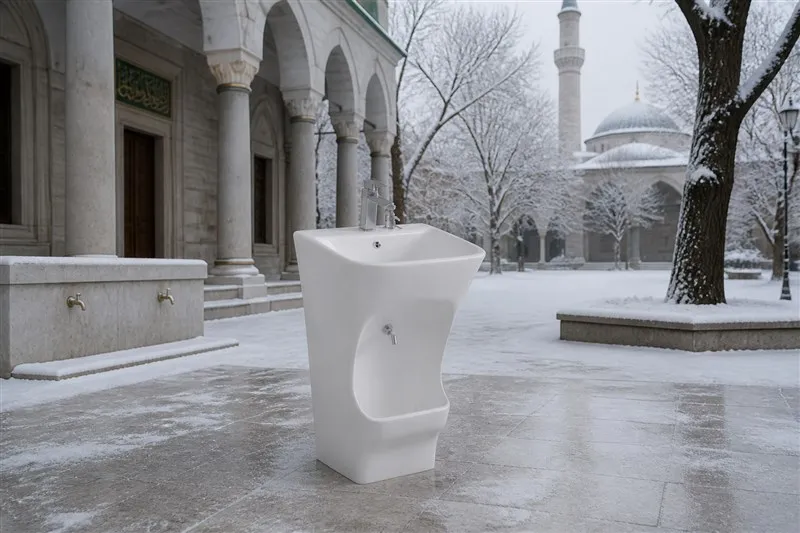 White ceramic wudu basin in a snowy mosque courtyard
