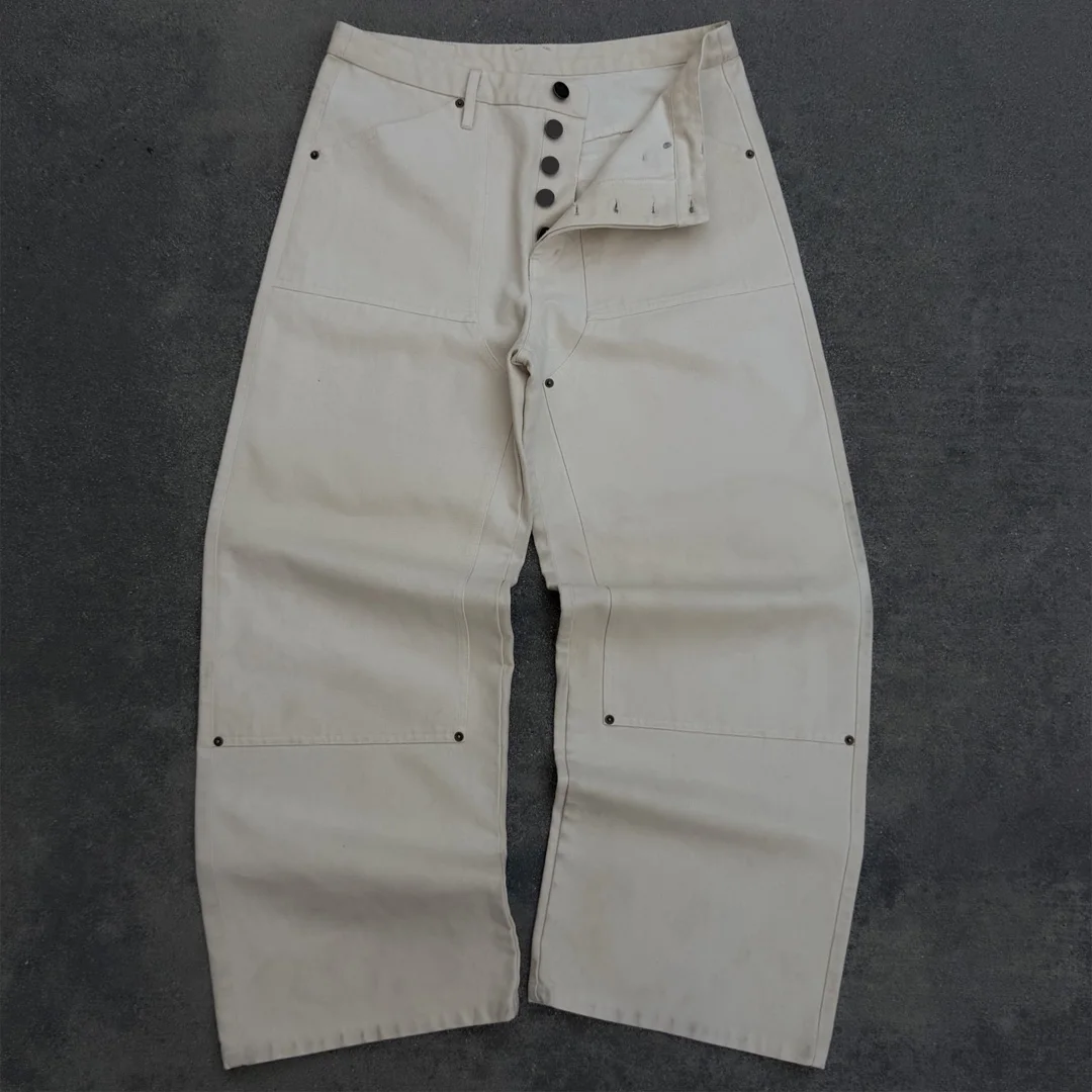 Niestandardowe dżinsy retro w stylu streetwear z 100% bawełny, z dzianiny, z szerokimi nogawkami, zużyte, z patchworkiem / nitami / opryskiem w stylu marmuru i ręcznie wykonanymi wzorami