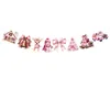 Guirlande de Noël rose avec motif maisonnette enneigée.