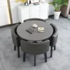 Mesa redonda gris + sillas de cuero negro.