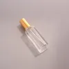 Botella transparente cuadrada con la tapa del oro