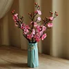 A ladylike blue vase with five pink plum blossoms