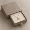 Cálido gris paloma con delicado grabado botánico y dorado tenue SunGene